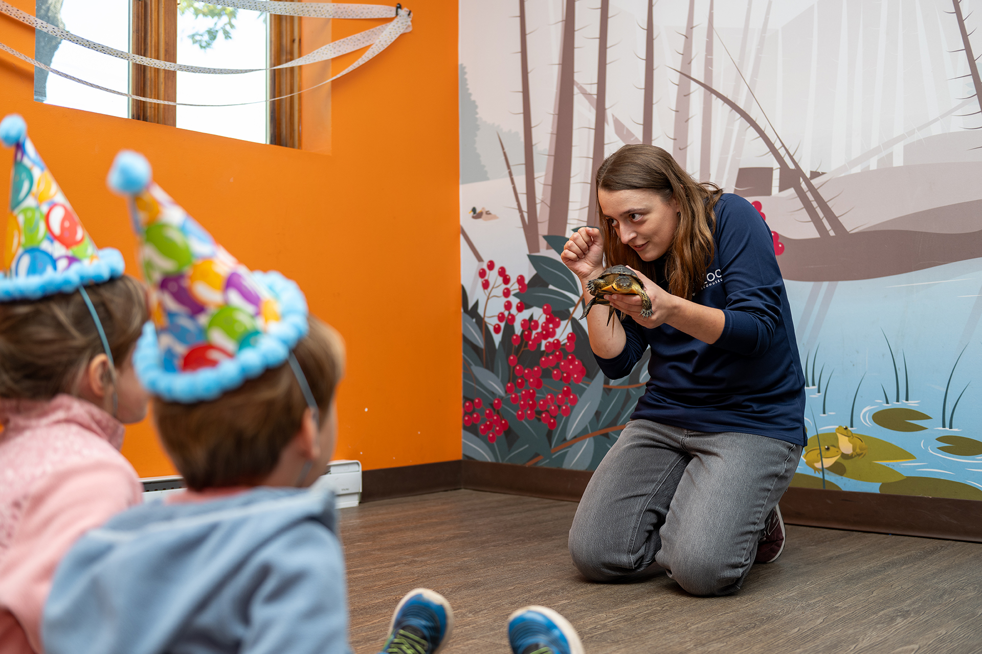 deux enfants qui regardent une tortue et une zoologiste
